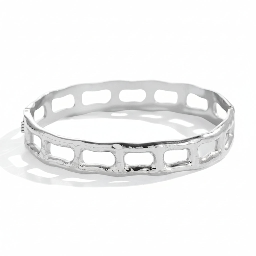 White gold-plated geometric bangle with architectural cutout frame design



