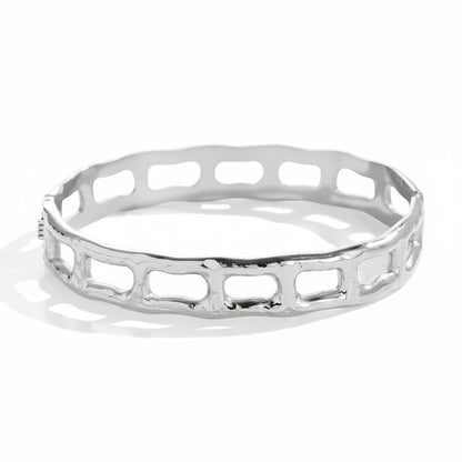 White gold-plated geometric bangle with architectural cutout frame design



