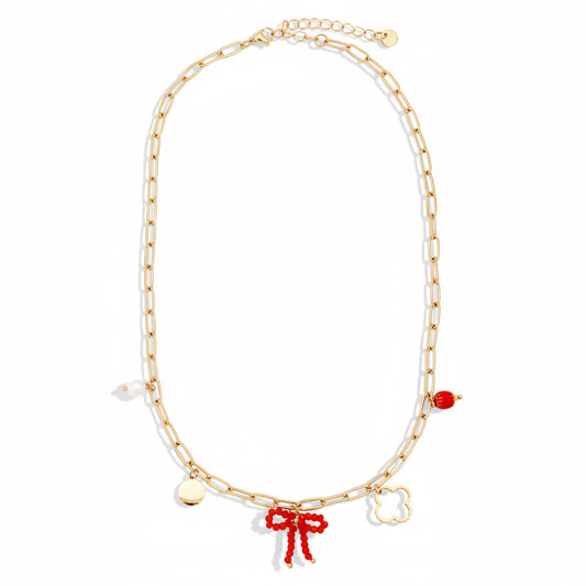 Gold-plated stainless steel paperclip chain necklace with curated charms including red beaded bow, quatrefoil, freshwater pearl, polished disc, and red crystal – ogrlica