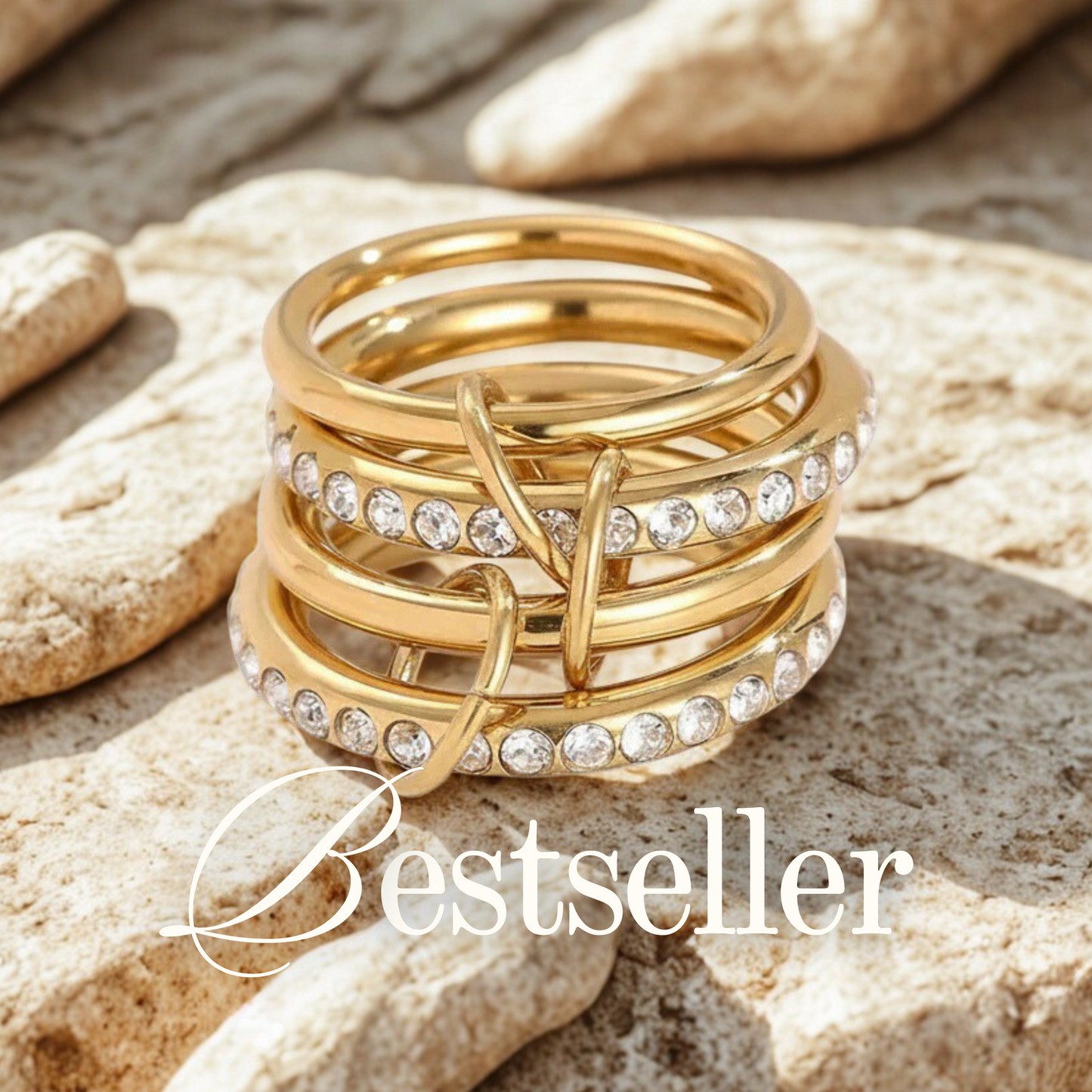 Stack of gold rings with embedded diamonds on a stone surface, labeled 'Bestseller'.