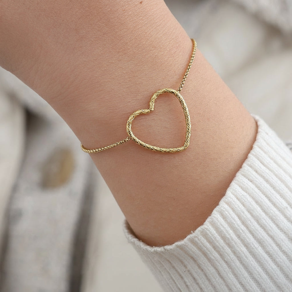 Gold twisted heart bracelet with rope-textured heart charm on delicate box chain