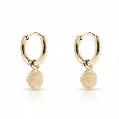 Gold-plated stainless steel huggie hoop earrings with an engraved Good Luck disc charm – naušnice