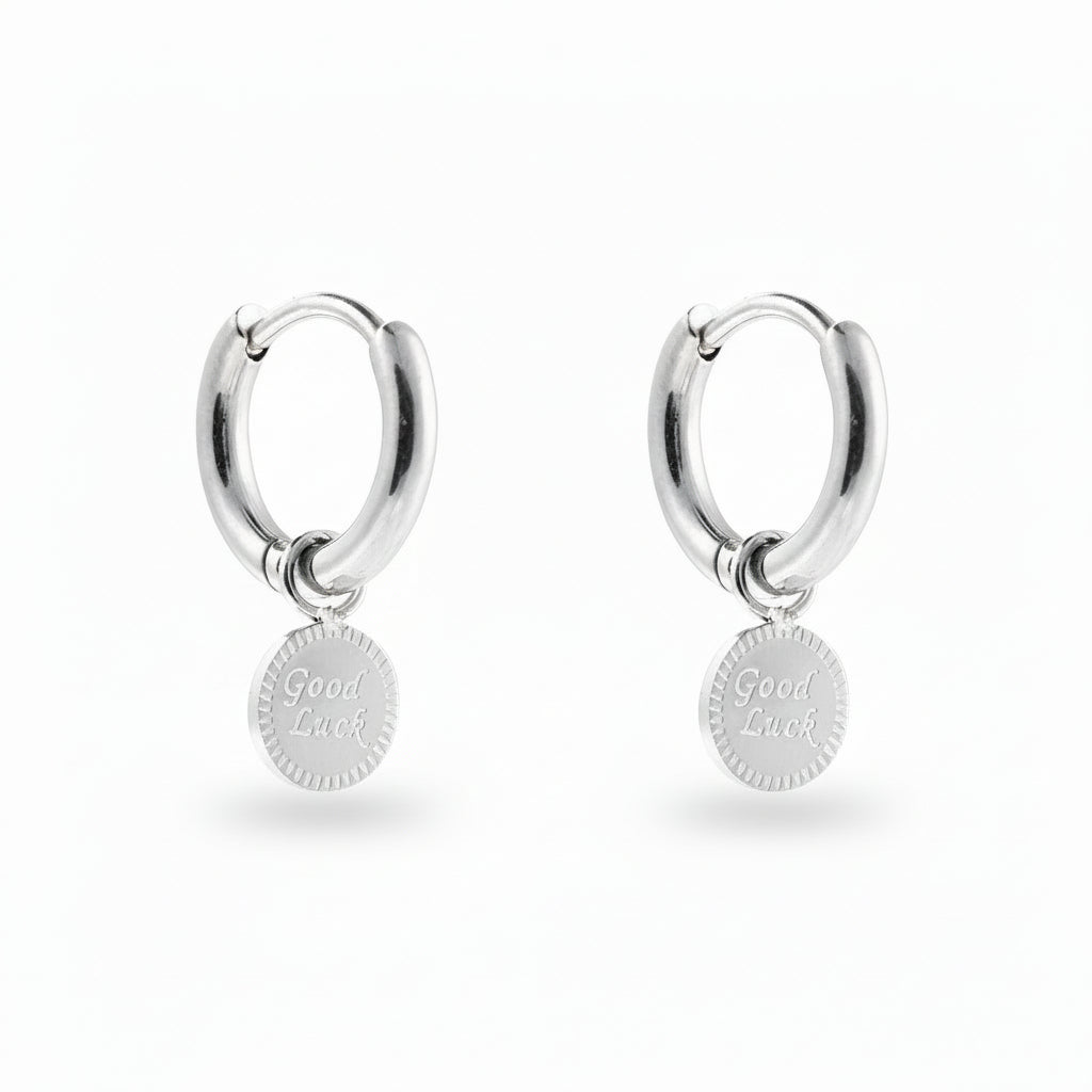 White Gold-plated stainless steel huggie hoop earrings with an engraved Good Luck disc charm – naušnice