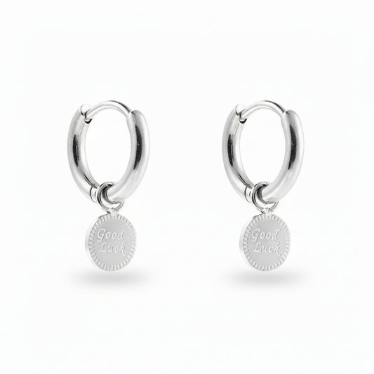White Gold-plated stainless steel huggie hoop earrings with an engraved Good Luck disc charm – naušnice