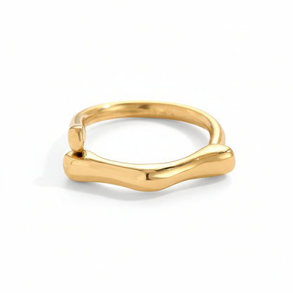 Gold ring with a modern design on a light gray background