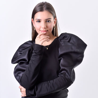 Woman wearing a black blouse with puffed sleeves on a white background
