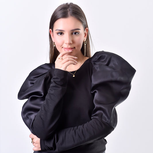 Woman wearing a black blouse with puffed sleeves on a white background