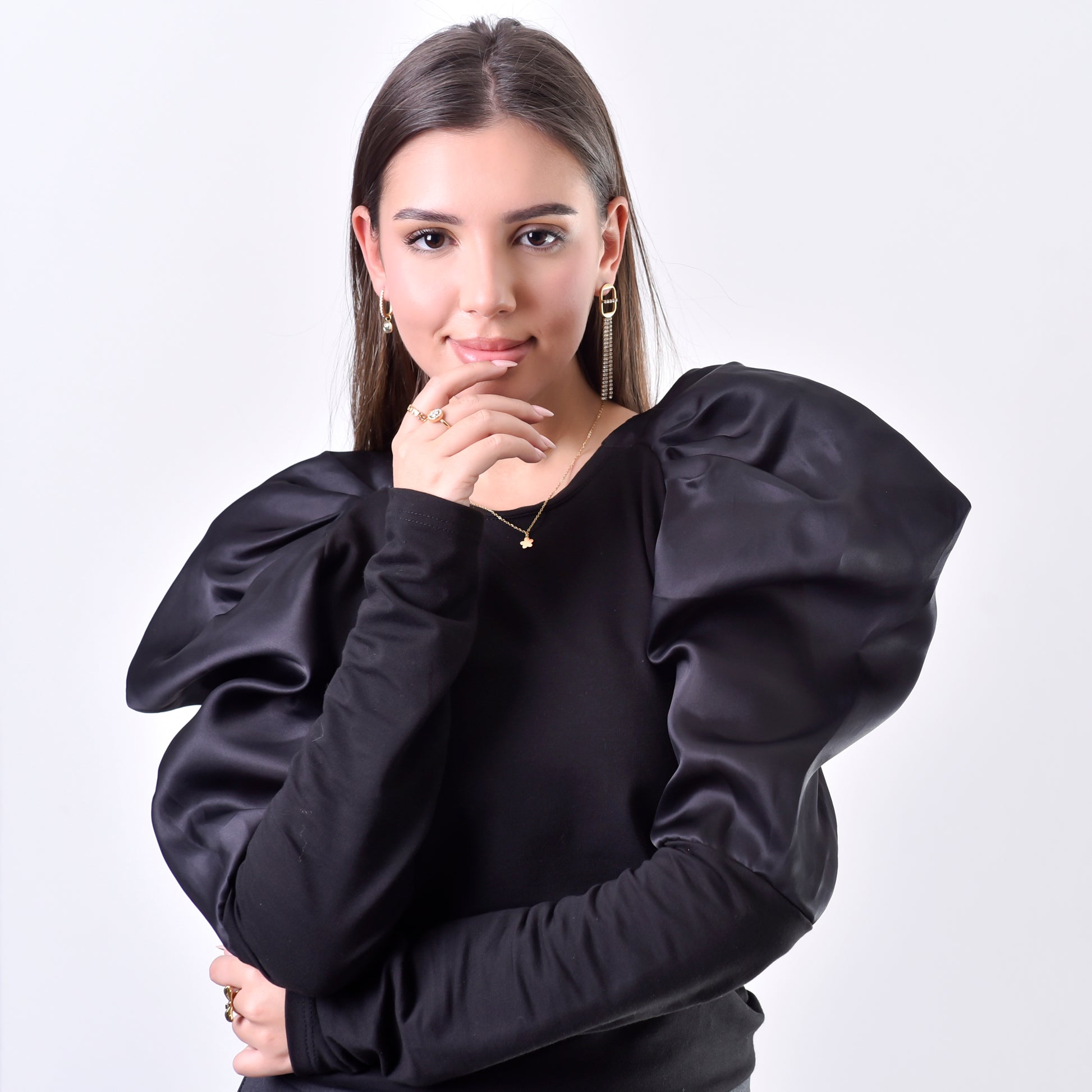 Woman wearing a black blouse with puffed sleeves on a white background