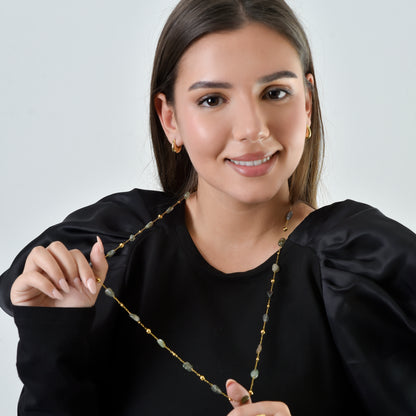 Woman holding a necklace with a plain background