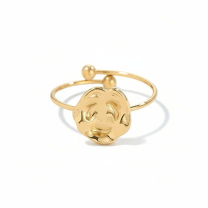 Gold ring with a circular design on a light gray background